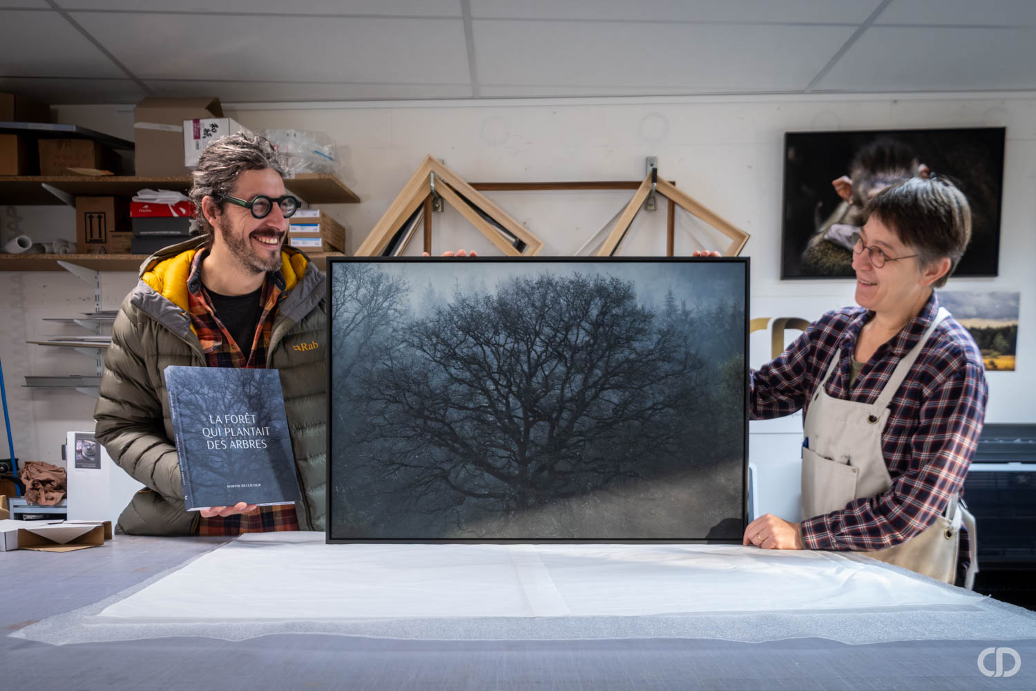Artiste et Claire Deprez heureux devant son oeuvre imprimée et encadrée à l'Atelier